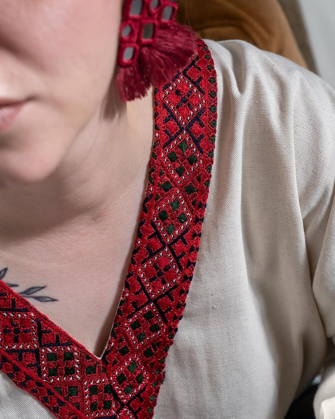 Close view of the red Balochi embroidery around the neckline of the linen blouse
