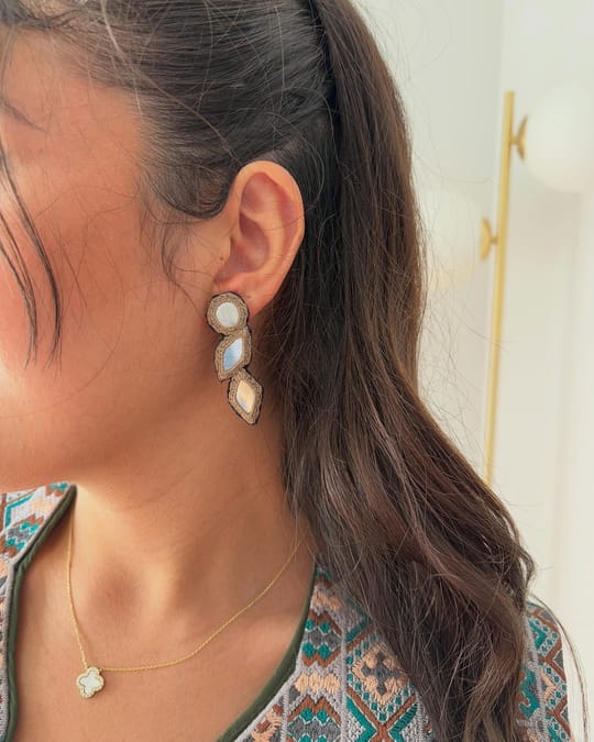 Silver mirror-work drop earring worn with an embroidered vest
