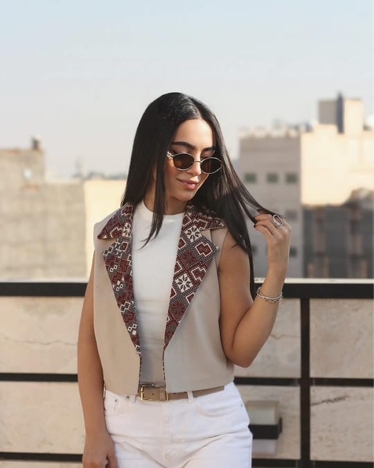Model on a rooftop in a sand coloured vest with embroidered lapels