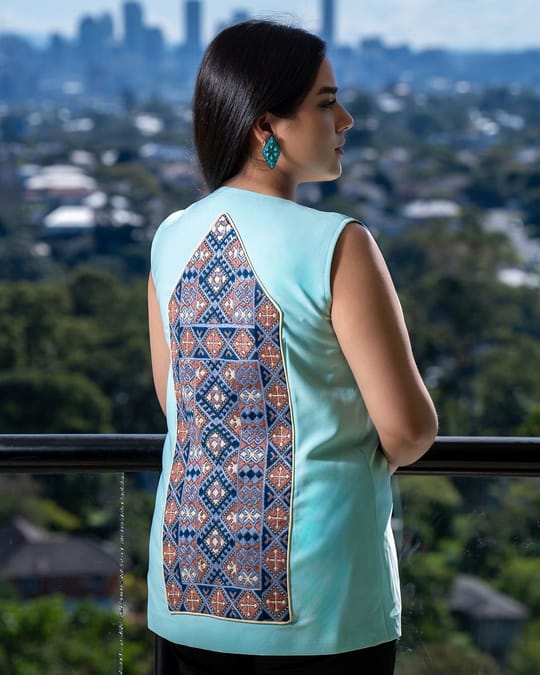 Back view of a mint vest with a long blue and gold embroidered panel