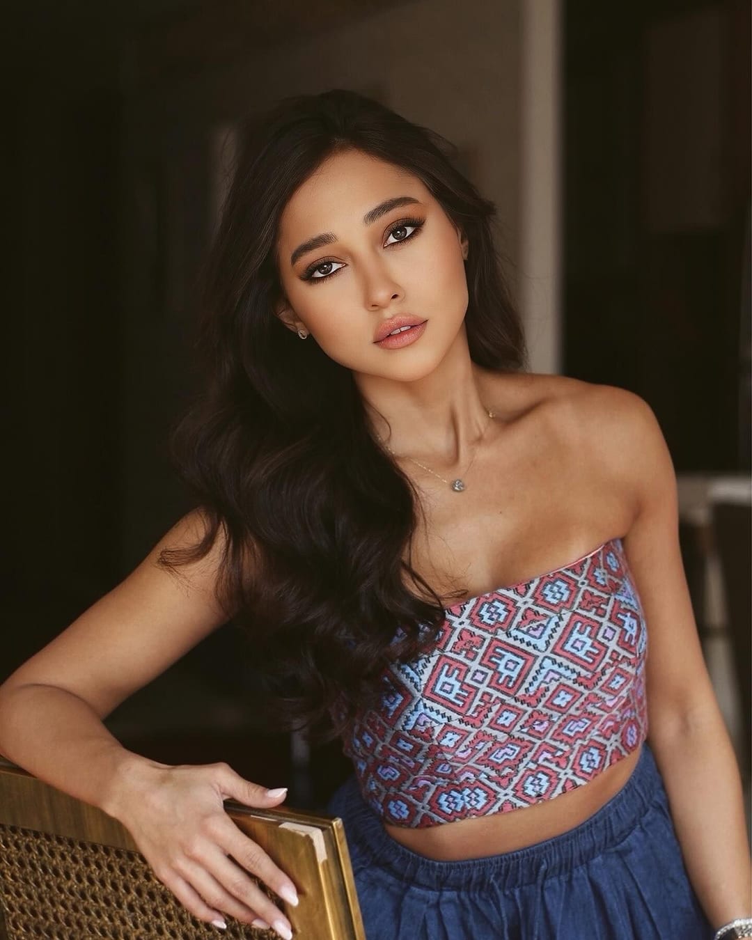Model in a strapless pink and pale blue embroidered crop top
