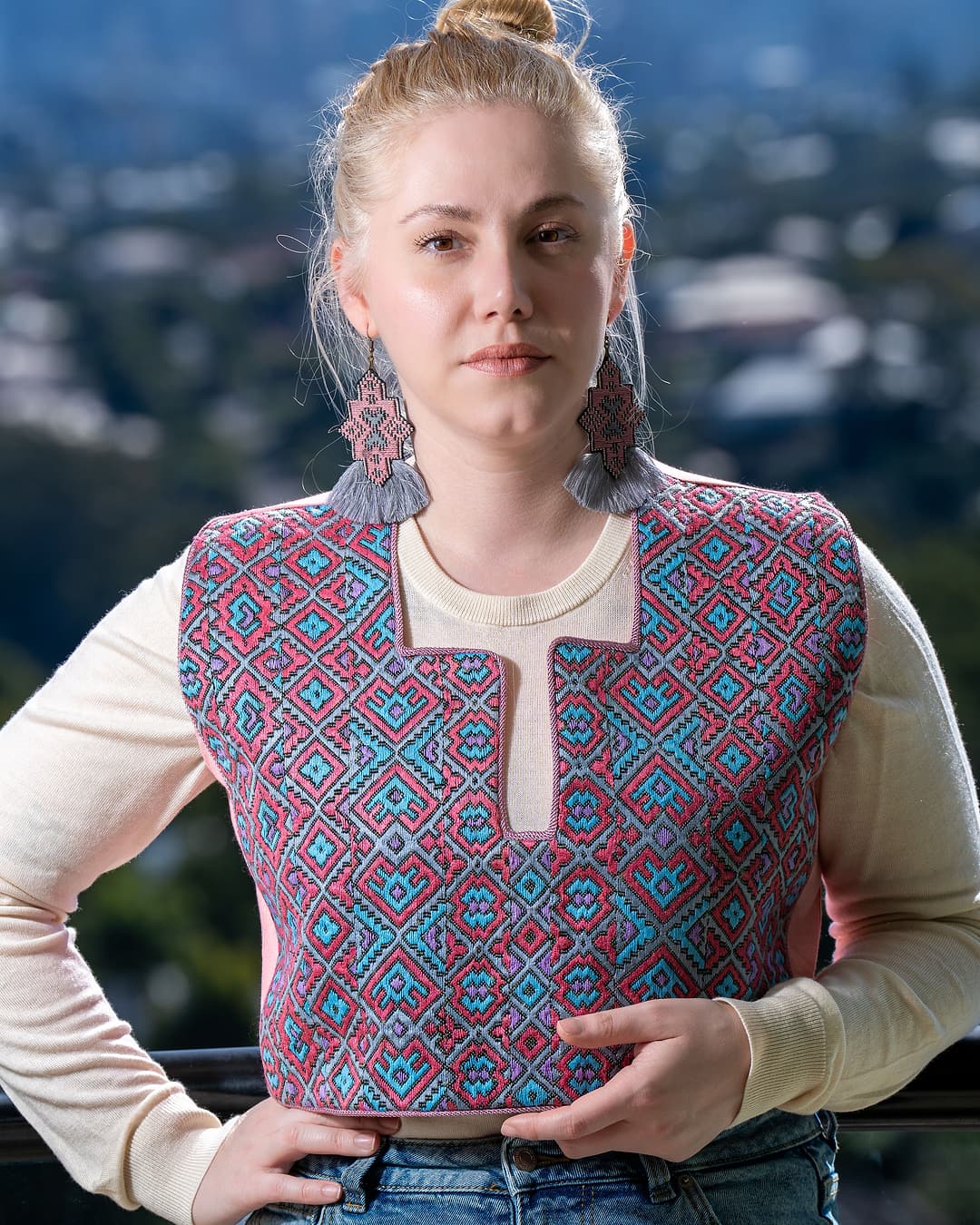 Front view of a pink and turquoise diamond embroidered vest with a split neckline