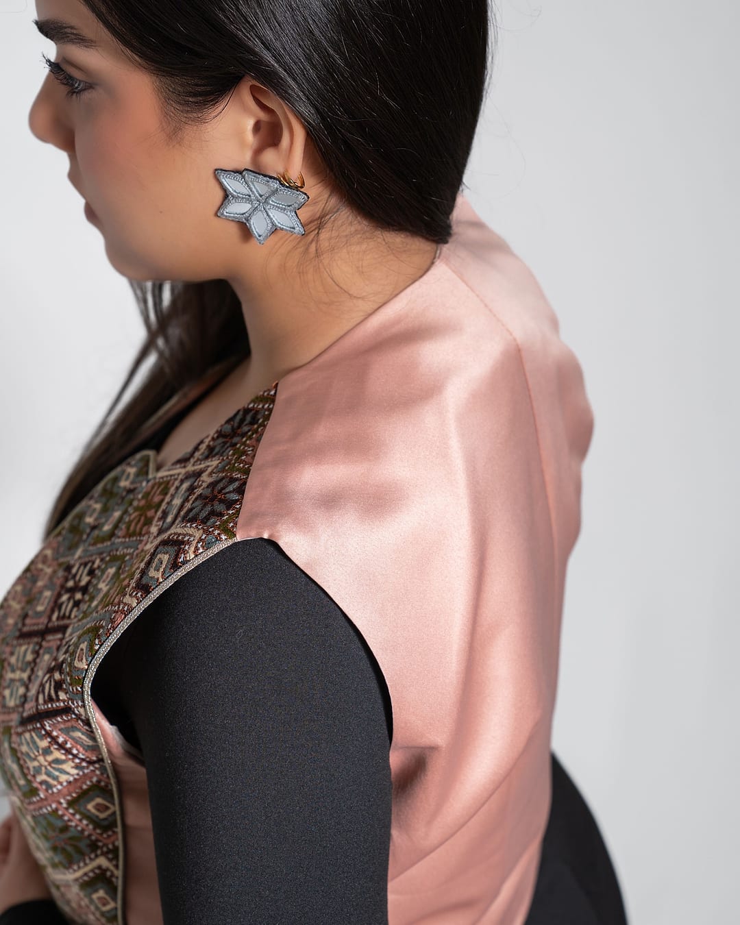 Side view of The Heirloom Vest, showing its pink satin back and embroidered front