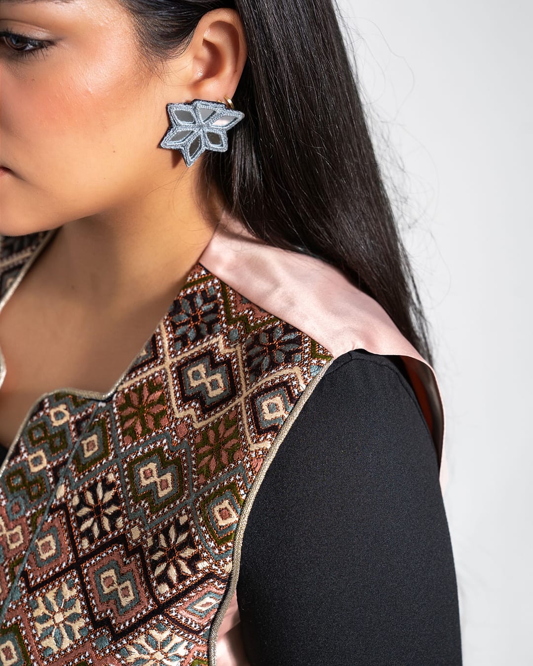 Detail of the embroidered front panel meeting the pink satin back