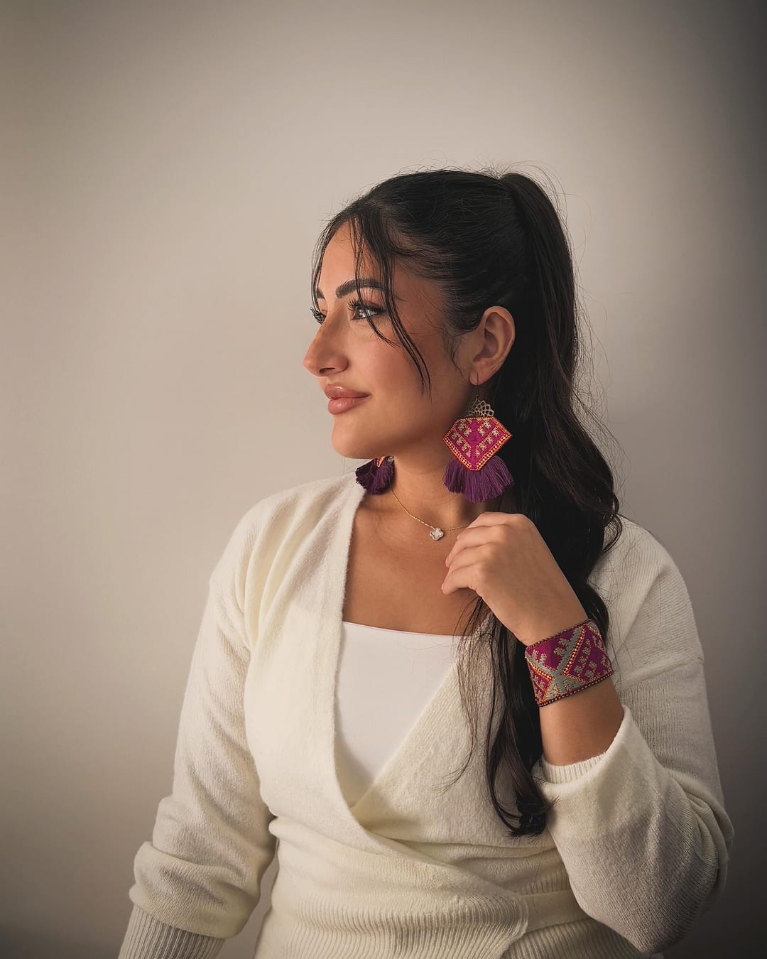 Model in cream wearing the Luna embroidered bracelet and earrings