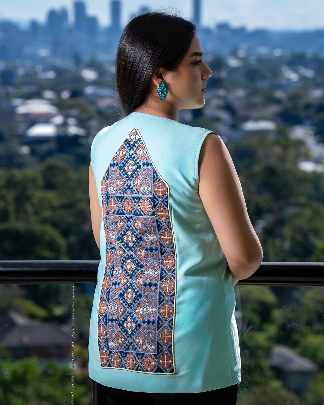 Back view of a mint vest with a long blue and gold embroidered panel
