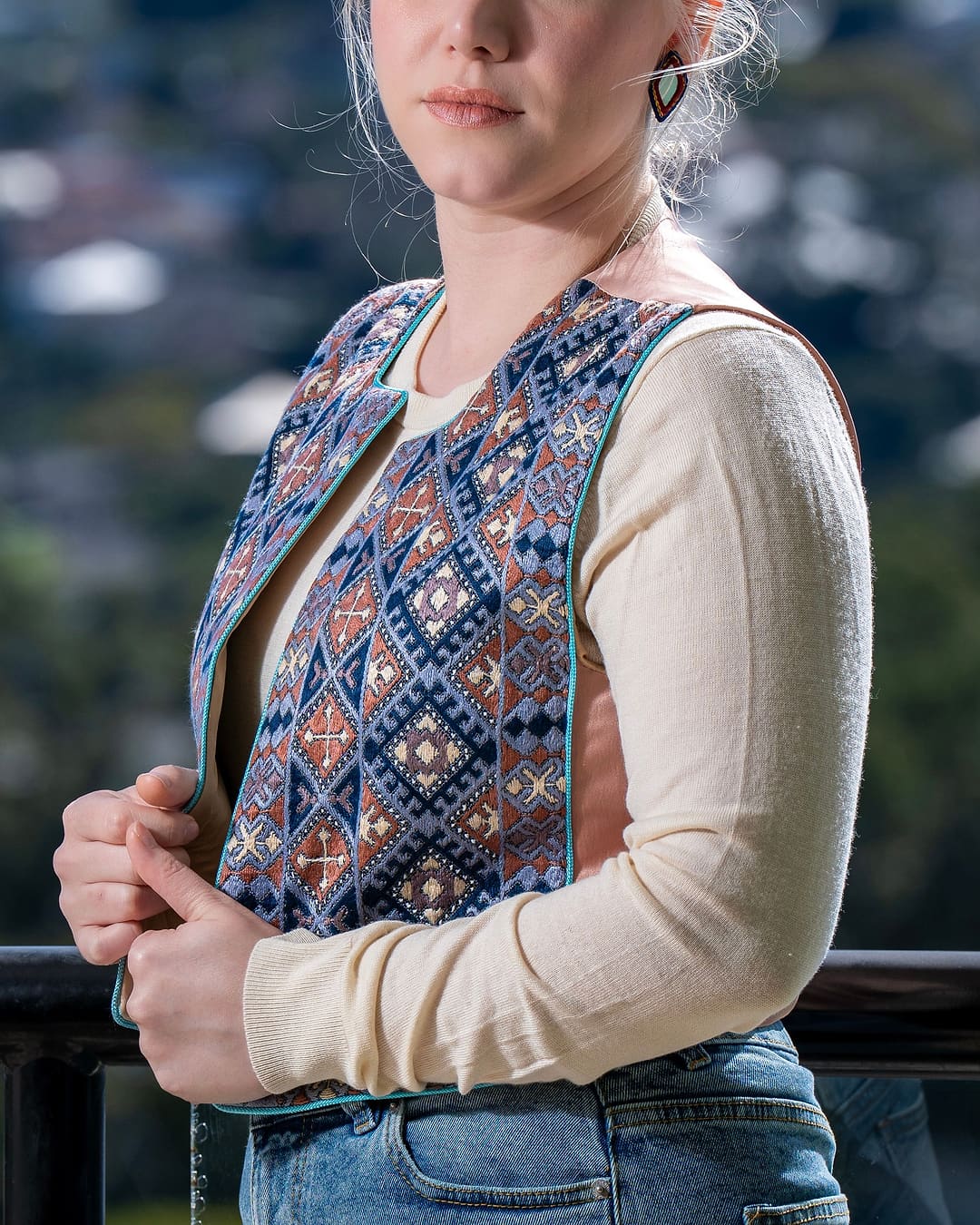 Indigo, rust and cream embroidered vest with turquoise piping, worn over a cream top